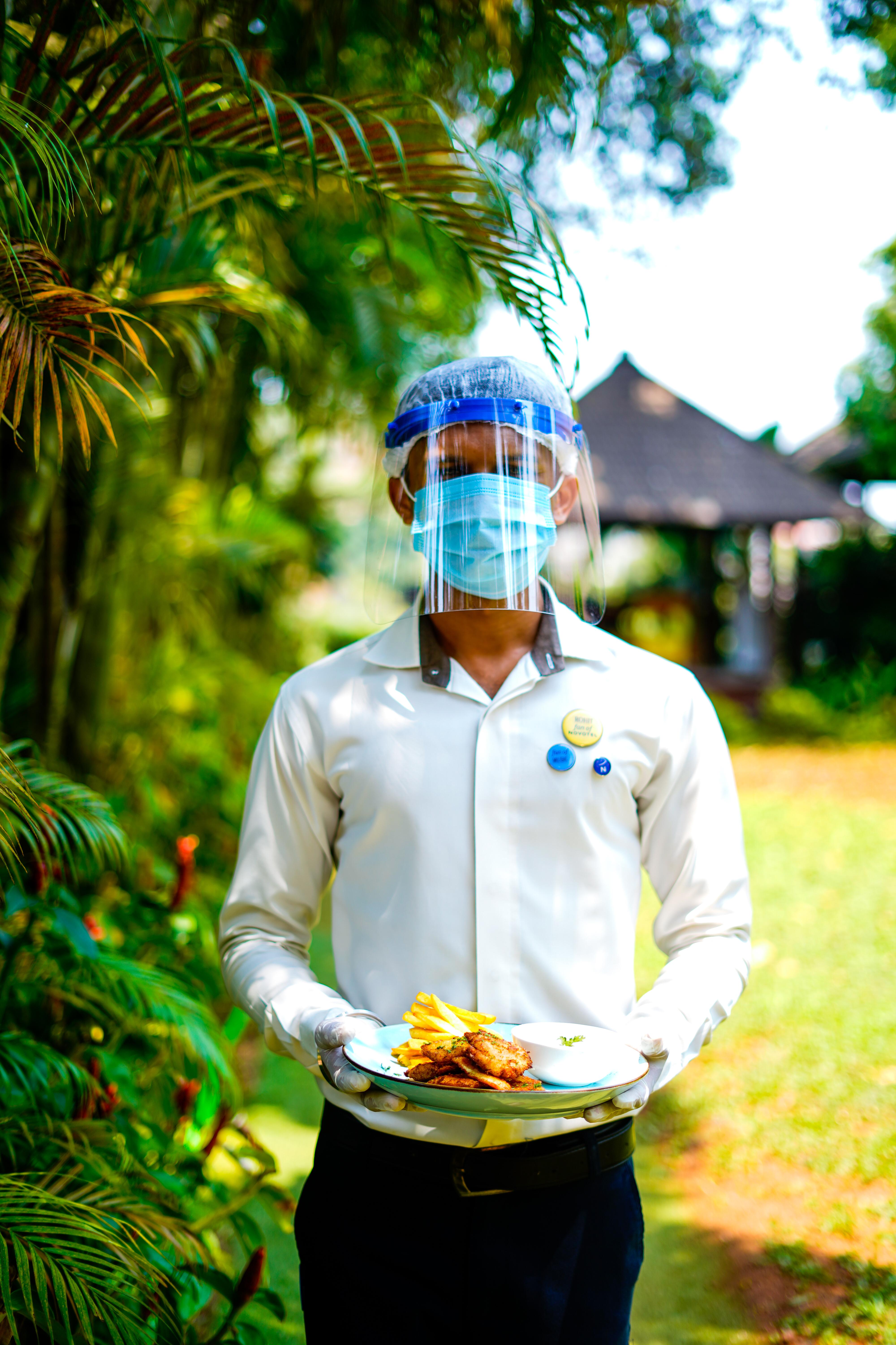 ノボテル ゴア リゾート&スパ アン アコーホテルズ ブランド カンドリム エクステリア 写真 A hotel employee wearing a face shield and a face mask