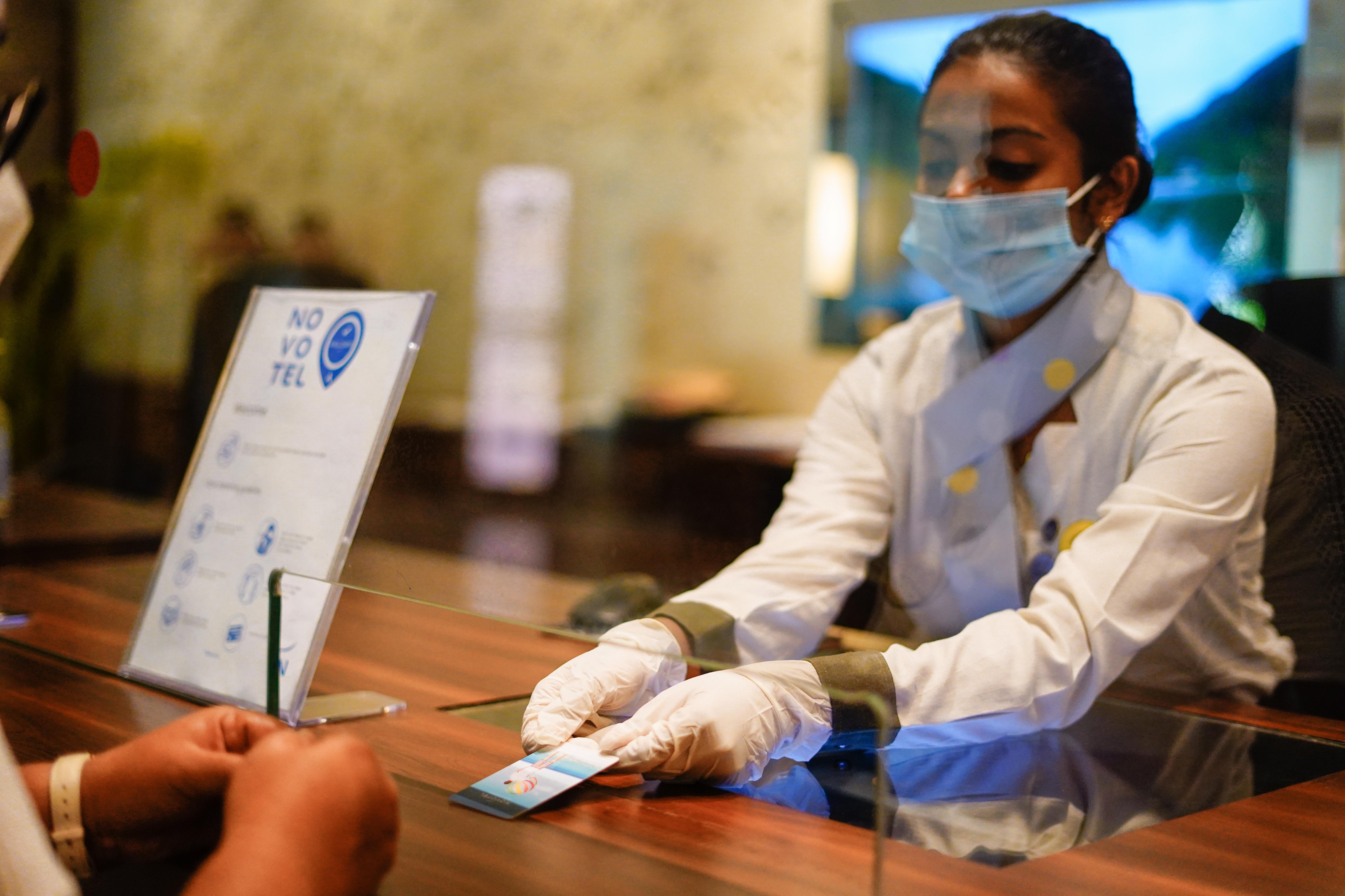 ノボテル ゴア リゾート&スパ アン アコーホテルズ ブランド カンドリム エクステリア 写真 A hotel employee wearing a face mask and gloves